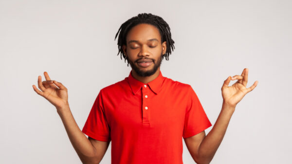Homem com olhos fechados em posição de meditação