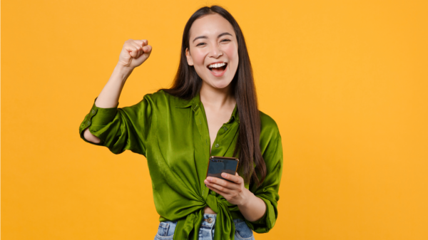 Mulher feliz com o celular na mão
