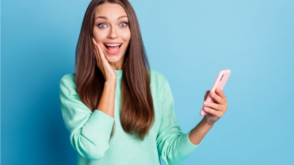 mulher feliz com o celular na mão