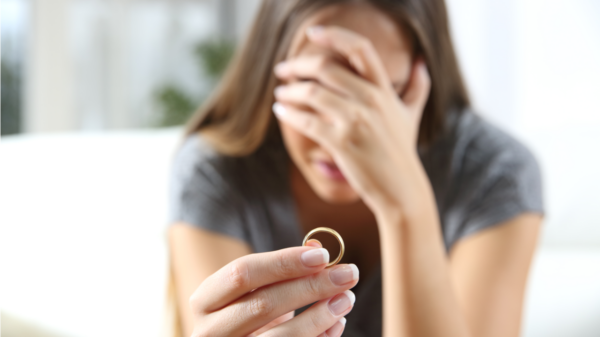 mulher segurando uma aliança com crise no casamento