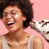 Mulher feliz com cão dálmata a cheirarando e mostrando devoção, isolados no fundo rosa. Mulher alegre com animal de estimação favorito. Pessoa e animal.