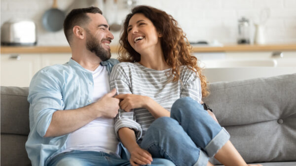 casal rindo sentado na sala