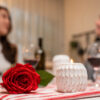 casal jantando com rosa vermelha e velas