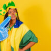 mulher torcendo para o brasil em fundo amarelo