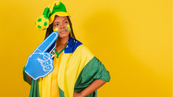 mulher torcendo para o brasil em fundo amarelo