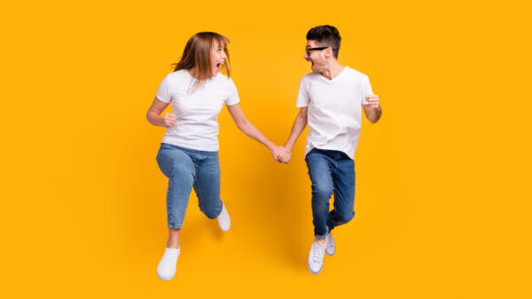 casal de mãos dadas em fundo laranja
