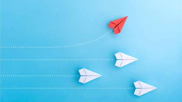 Aviõezinhos de papel em uma direção e com um deles apontando de maneira diferente. Conceito de oportunidade de crescimento.