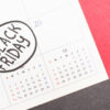 Inscrição "Black Friday" no calendário de 2022 sobre fundo vermelho.