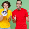 uma mulher feliz com megafone na mão e um homem com a bola na mão