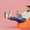 homem com um computador no colo feliz