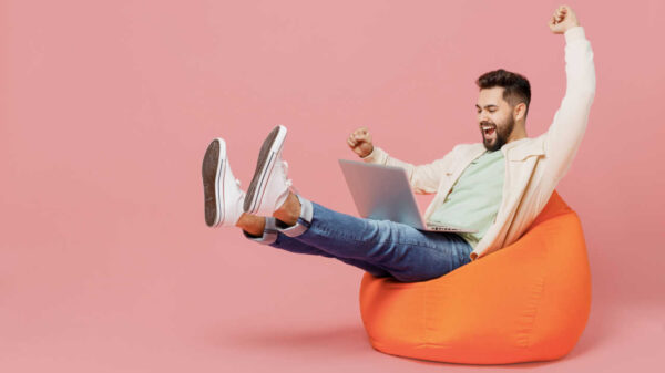 homem com um computador no colo feliz