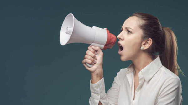 Mulher mandona e irritada dando ordens por meio de um megafone.
