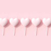 Doces em forma de coração cor-de-rosa no fundo rosa.