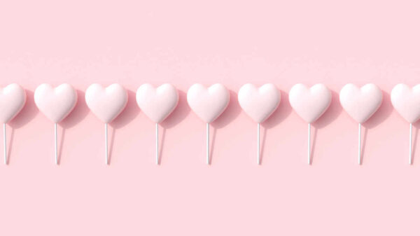 Doces em forma de coração cor-de-rosa no fundo rosa.