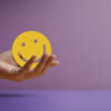 Mente positiva. Conceito de vida. Mão segurando um papel de rosto sorridente. Bem-estar e estilos de vida saudável. Sociabilidade.
