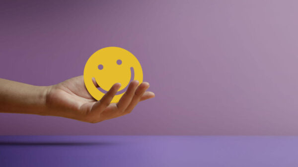Mente positiva. Conceito de vida. Mão segurando um papel de rosto sorridente. Bem-estar e estilos de vida saudável. Sociabilidade.