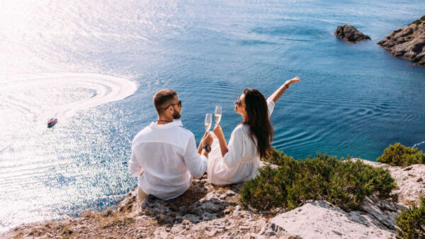 casal vestido em roupas brancas na frente do mar