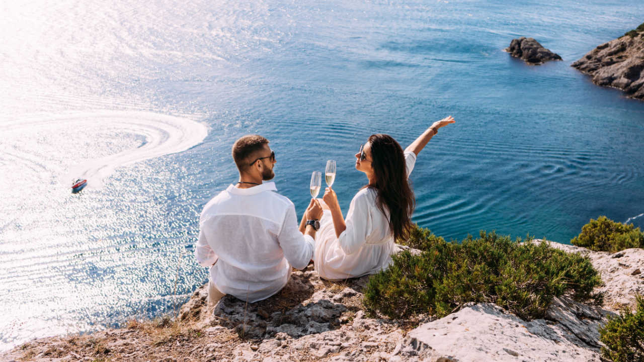casal vestido em roupas brancas na frente do mar