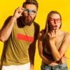 Retrato de homem e mulher surpresos e atônitos, olhando para a câmera, com expressão facial chocada, vendo algo incrível. Foto em estúdio isolado no fundo amarelo.