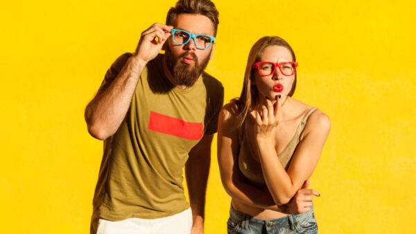 Retrato de homem e mulher surpresos e atônitos, olhando para a câmera, com expressão facial chocada, vendo algo incrível. Foto em estúdio isolado no fundo amarelo.