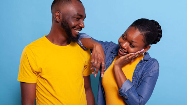 Mulher e homem flertando um com o outro em um estúdio, fazendo gestos fofos de amor. Mulher expressando carinho e paixão, sentindo-se feliz com o homem. Casal sorridente e alegre.
