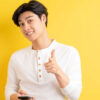 homem com traços asiaticos em fundo amarelo