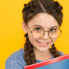 Estudante sorridente. Menina colegial. Aluna com tranças. Conceito de estudos.
