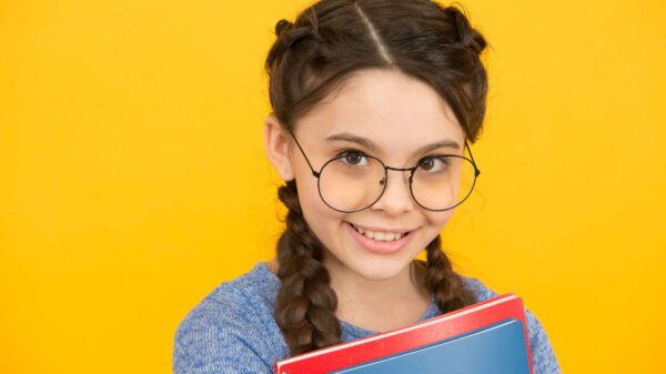 Estudante sorridente. Menina colegial. Aluna com tranças. Conceito de estudos.