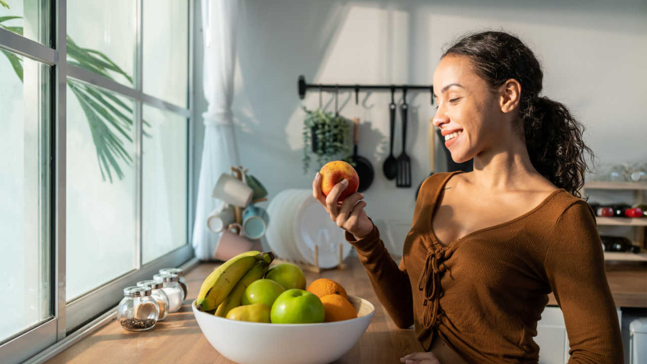 mulher segurando frutas