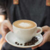 xícara de café com grãos de café ao lado