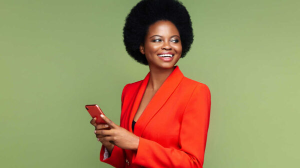 mulher negra com terno laranja em fundo verde