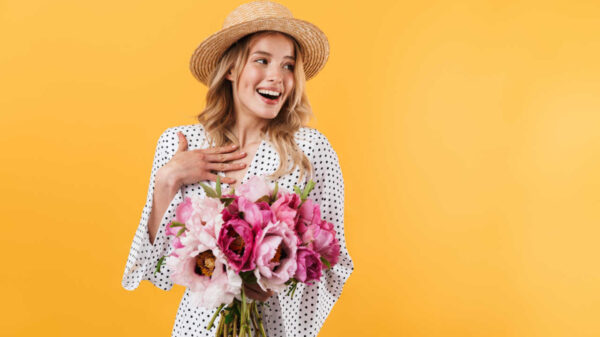 mulher com buque de rosas em fundo amarelo
