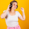 Mulher adulta, usando fones de ouvido, dançando e festejando.