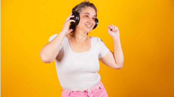 Mulher adulta, usando fones de ouvido, dançando e festejando.