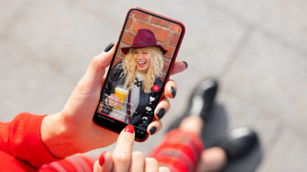mão segurando um celular com o com aplicativo do tik tok aberto