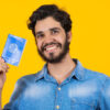 Homem segurando Carteira de Trabalho e Previdência Social.