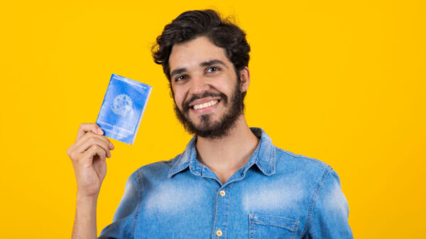 Homem segurando Carteira de Trabalho e Previdência Social.