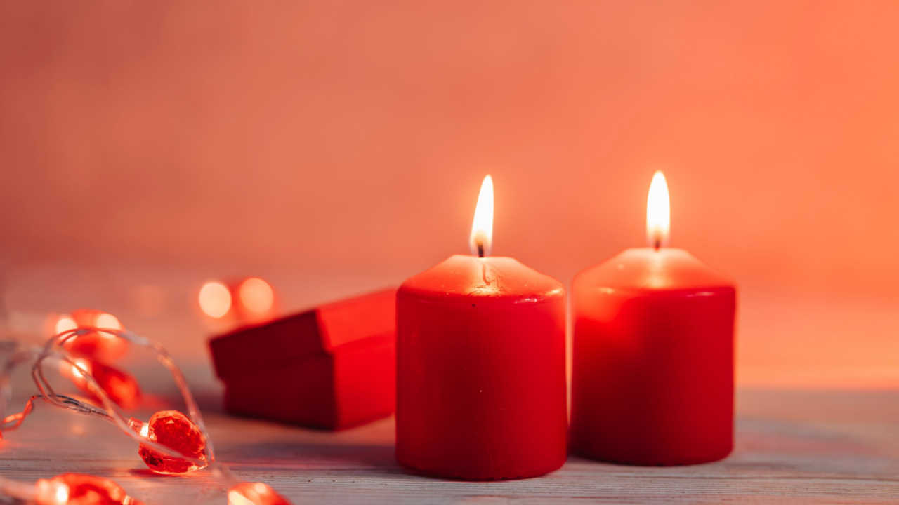 duas velas vermelhas em um fundo vermelho