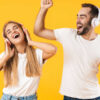casal com fone de ouvido em fundo amarelo