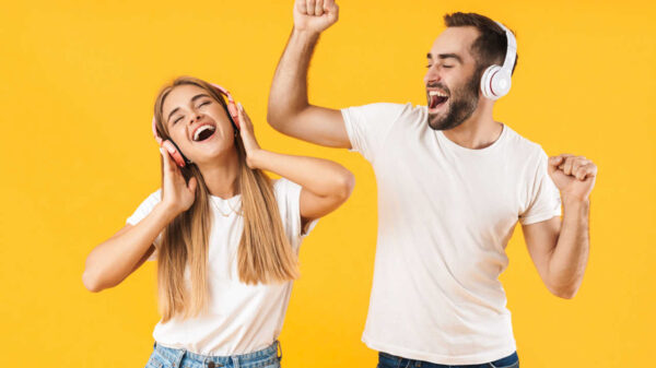 casal com fone de ouvido em fundo amarelo