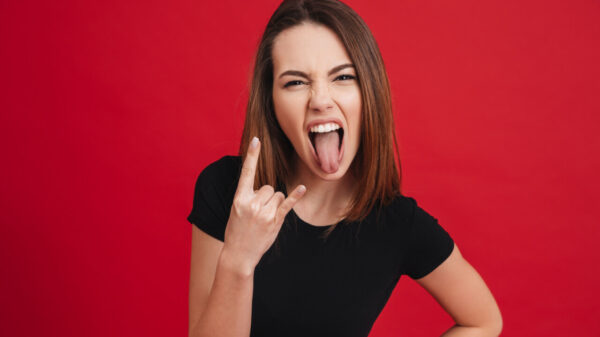 Retrato de uma garota rebelde, isolada sobre um fundo vermelho.