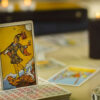 Cartas de tarô empilhadas e a carta dO Louco em pé, entre elas.