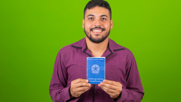 Homem segurando o documento de trabalho e segurança social, (Carteira de Trabalho e Previdência Social).