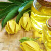 flores e óleo essencial de ylang ylang em um cesto tipo madeira