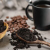 Grãos de café em uma colher de pau.