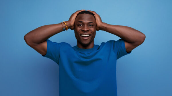 Homem vestido com uma camiseta básica, posando e sorrindo. Conceito de estilo de vida.