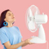mulher jovem vestindo roupa azul e segurando nas mãos um ventilador branco em fundo rosa
