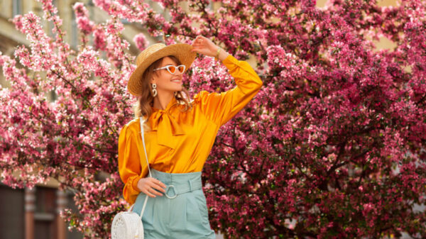 mulher posando para foto com uma árvore florida ao fundo