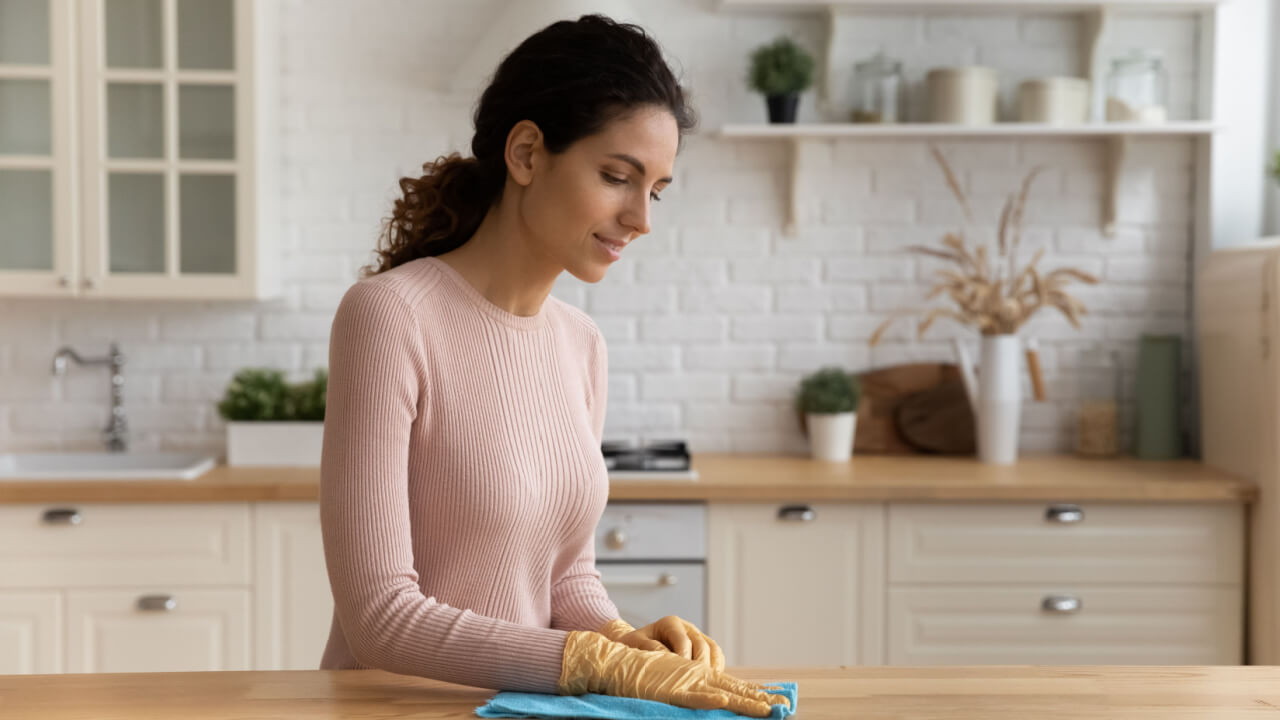 mulher limpando a bancada da cozinha