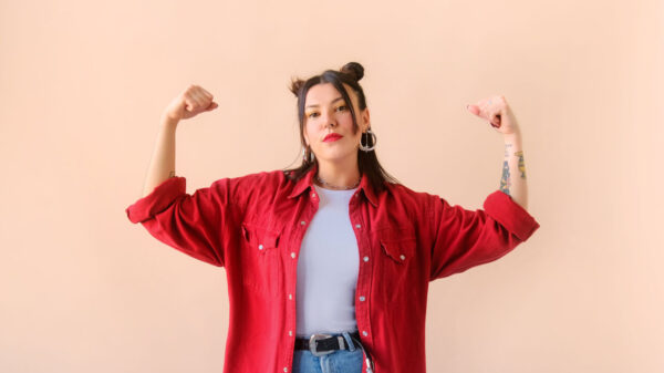 Mulher forte e poderosa, com os braços levantados.